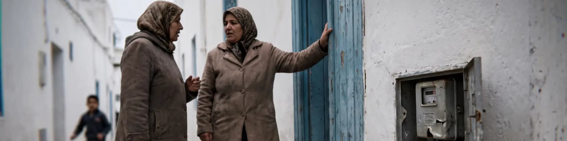 Two neighbours talking in an alley of the Tunis medina